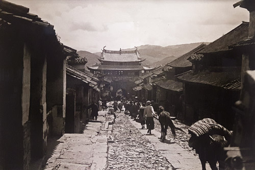 People walking downhill to Chinese gatehouse