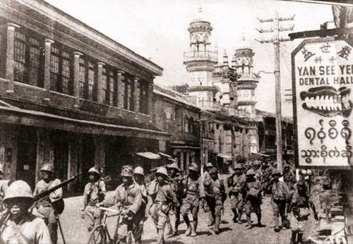 Japanese troops walking past a mosque