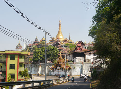 Burmese pagoda with traffic and new buildings